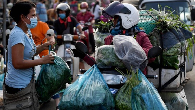Cambojana compra vegetais na rua enquanto os mercados permaneciam fechados em meio a restrições introduzidas para tentar impedir um aumento de casos do coronavírus Covid-19 em Phnom Penh. (Foto de TANG CHHIN Sothy / AFP)