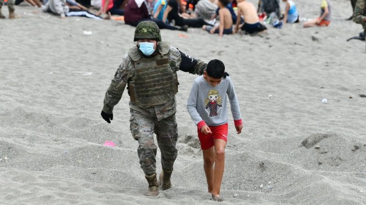 Un soldado español camina con un menor migrante a su llegada al enclave español de Ceuta, el 18 de mayo de 2021. 