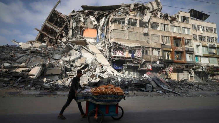 Terra Santa. Um palestino passa por um prédio destruído na Cidade de Gaza, após bombardeio aéreo israelense. (AFP)