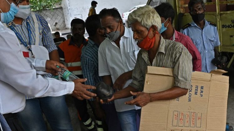 Mitglieder einer Freiwilligenorganisation beim Austeilen von Essen an Bedürftige in Indien 