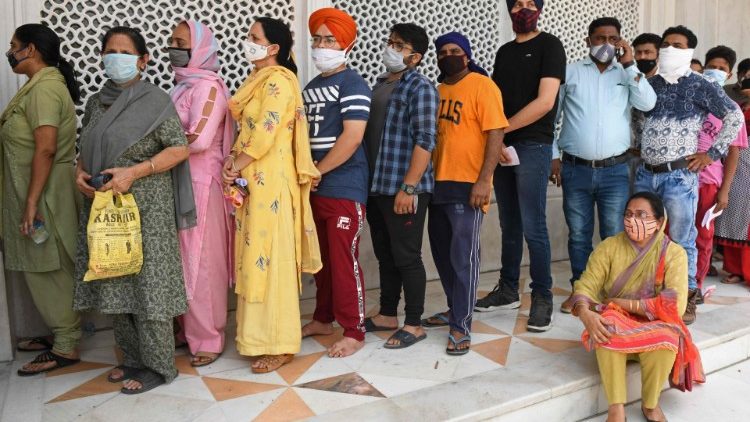 People in India queue to receive vaccine