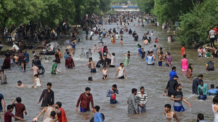Wegen der Hitze kühlen sich viele Menschen in Lahore in einem Kanal ab