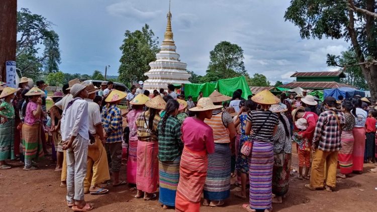 Displaced people in Myanmar's Shan state await food aid at a Buddhist monastery. 