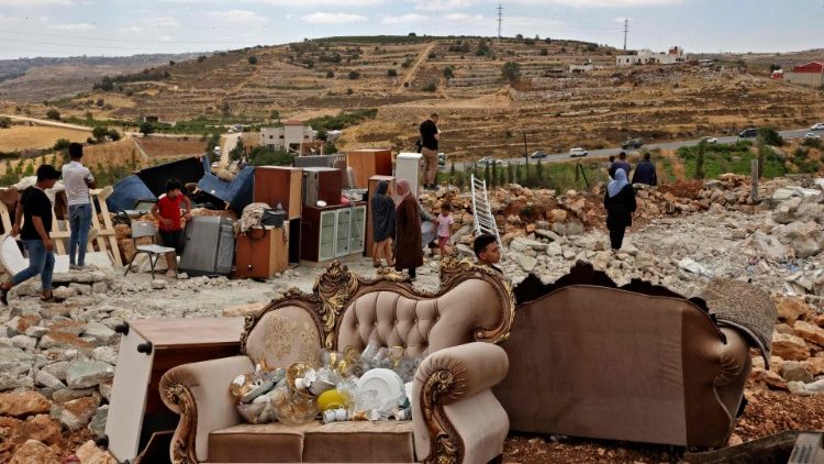 Membros de uma família palestina verificam seus pertences depois que máquinas israelenses demoliram sua casa localizada na Cisjordânia ocupada (AFP)