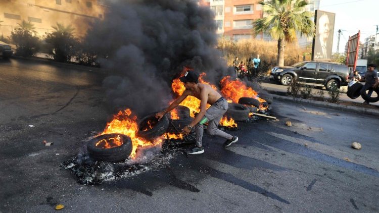  A Lebanese youth sets tires on fire during a protest in Lebanon's capital Beirut against dire living conditions. 