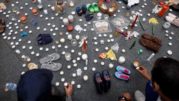 Flores, velas, pequenos calçados na vigília em recordação das crianças indígenas vítimas das escolas residenciais no Canadá. (Photo by Cole Burston/AFP)