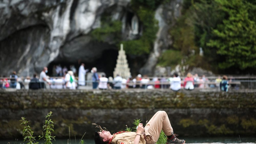 Escoteiro descansa em frente  Gruta de Massabielle, enquanto o Santurio catlico de Notre Dame de Lourdes recebe os peregrinos aps meses de fechamento devido  pandemia. (Photo by MATTHIEU RONDEL / AFP)