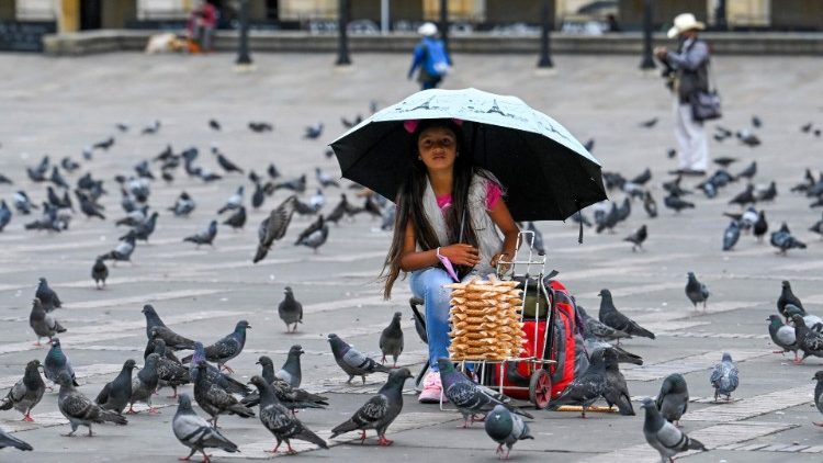 Una niña vende maíz para palomas en la plaza de Bolívar de Bogotá el 7 de julio de 2021