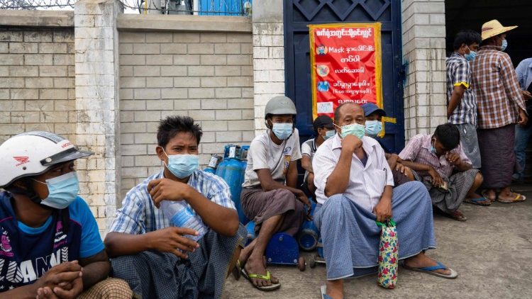 Хора, които чакат да напълнят празни кислородни бутилки пред фабрика в Мандалай на фона на пандемията.