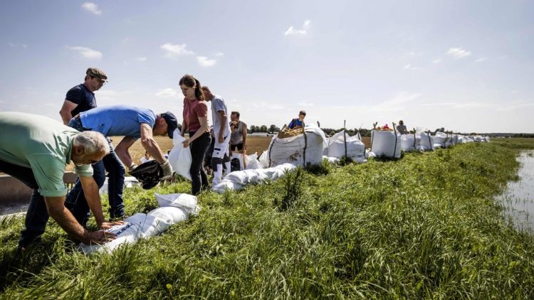 People in the Netherlands area of Limbourg place sandbags following heavy rains and floods