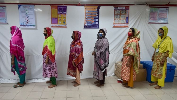 Trabalhadores de confecções esperam em uma fila para receber uma dose da vacina Moderna contra o coronavírus Covid-19 em Konabari, a cerca de 40 km de Daca. (Foto de Munir Uz zaman / AFP)