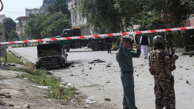 Afghan security personnel stand guard after the rocket attack near the presidential palace