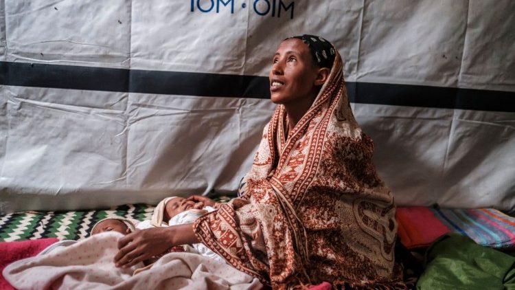 An internally displaced woman from Ethiopia's Tigray region shelters at a camp in the town of Azezo, Ethiopia