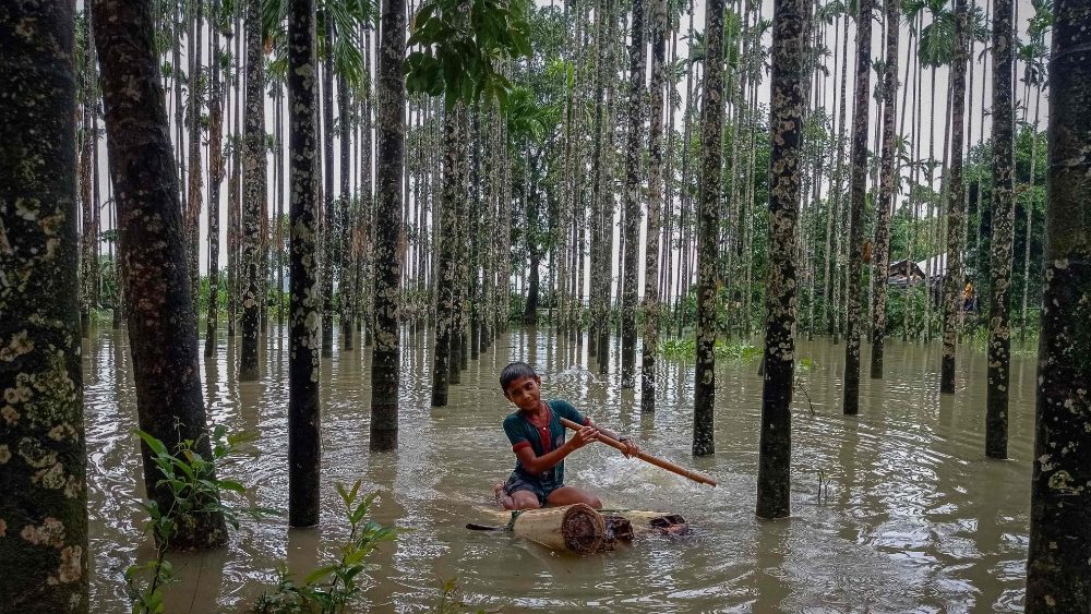 Menino rema em barco improvisado em rea inundada em Maulovir Para, Cox's Bazar