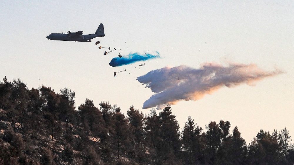 Uma aeronave Lockheed C-130 Hercules libera retardante de fogo ao tentar extinguir um incndio florestal perto do Kibutz Tzova no centro de Israel a oeste de Jerusalm em 17 de agosto de 2021. (Foto de Ahmad GHARABLI / AFP)