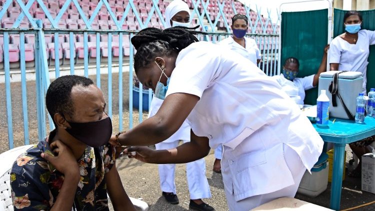 Médica da Tanzânia injeta dose da vacina desenvolvida pela farmacêutica Johnson & Johnson, durante uma campanha de vacinação em massa no Uhuru Stadium em Dar es Salaam, em 22 de agosto de 2021. (Foto por STRINGER / AFP)