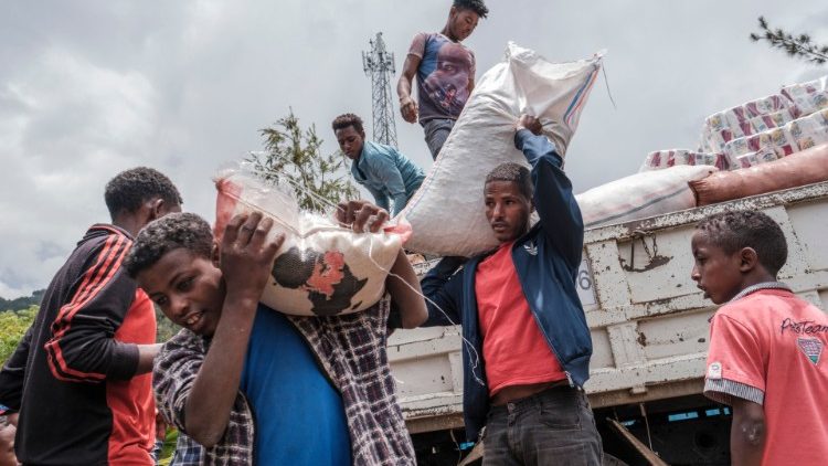 Durch den Tigray-Konflikt intern Vertriebene packen in der äthiopischen Stadt Dessie mit an, um einen Laster mit Lebensmittelhilfen zu entladen