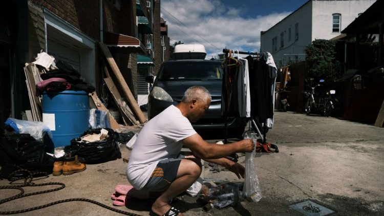 न्यू जर्सी में तूफान के बाद अपने घरों को साफ करते लोग