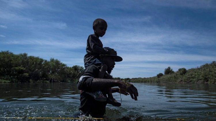 Pai e filho haitianos cruzam o rio Rio Grande na Ciudad Acuna, Estado de Coahuila, México