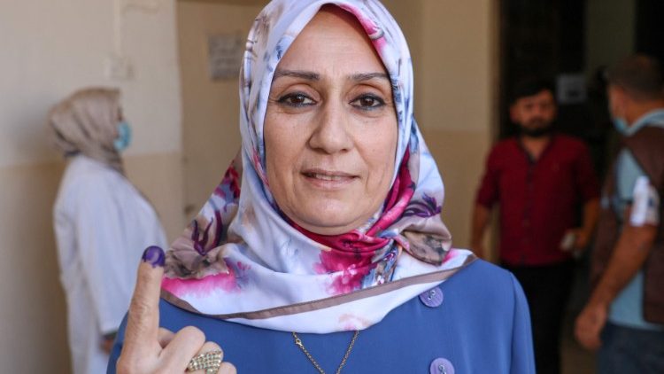 An Iraqi woman shows her ink-stained finger after casting her vote at a polling station in the northern city of Kirkuk