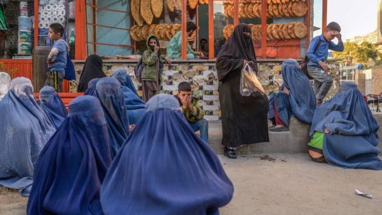 Donne afgane attendono il turno per ricevere una razione di pane (AFP)