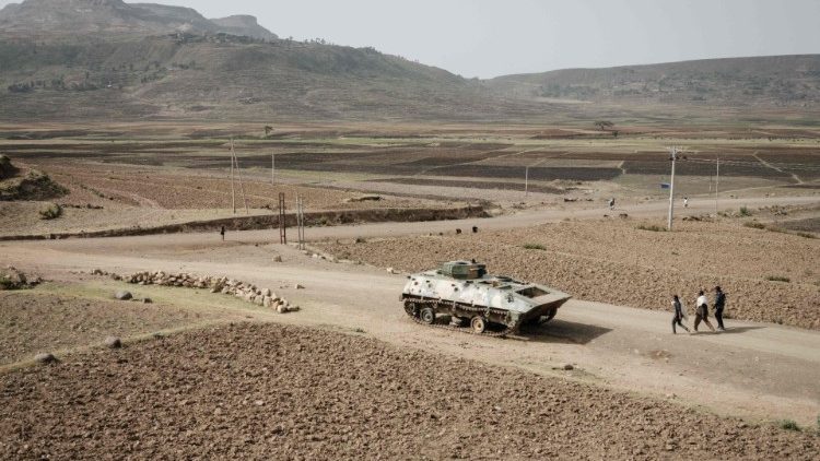 Menschen gehen an einer Straße in der Tigray-Region an einem verlassenen Panzer vorbei (Archivbild)