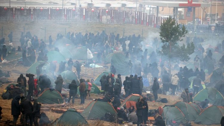 Migranti ammassati lungo la frontiera che divide Belarus e Polonia, dove sono avvenuti gli scontri con la polizia polacca (Afp)