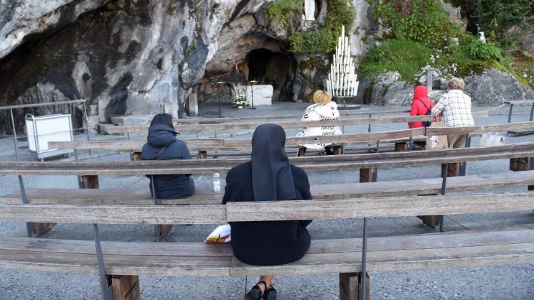 Faithful at the cave of Massabielle in Lourdes