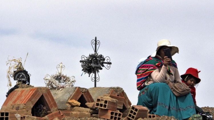 Boliviana sentada ao lado de túmulos em Caracollo, proximidades de La Paz