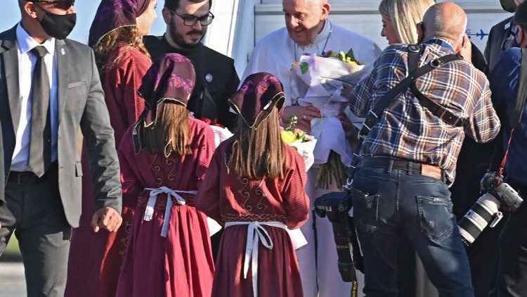 Children welcoming the Pope with flower bouquets.
