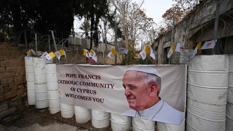 Uno striscione con l'immagine del Papa a fianco alla barriera che segna l'inizio della zona cuscinetto delle Nazioni Unite accanto alla Chiesa di Santa Croce a Nicosia