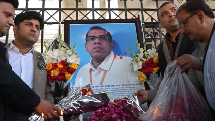 Pakistanische Industrielle gedenken am 4. Dezember 2021 in Sialkot neben einem Foto des verstorbenen Fabrikmanagers aus Sri Lanka, der von einem Mob, der ihn der Blasphemie beschuldigte, zu Tode geprügelt und in Brand gesetzt wurde.