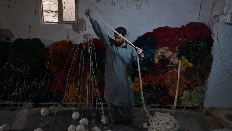 An Afghan worker makes skeins of wool, Herat