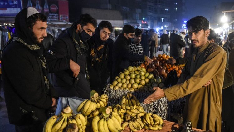 La gente compra fruta en un puesto de carretera en un mercado de Jalalabad