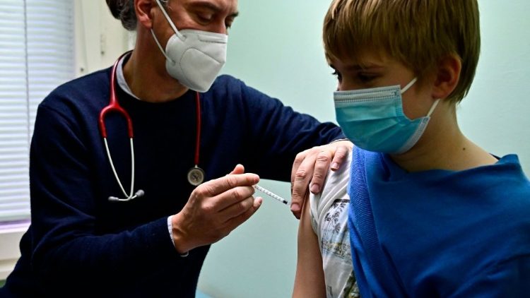 जर्मनी में एक बच्चा वैक्सीन लेते हुए
