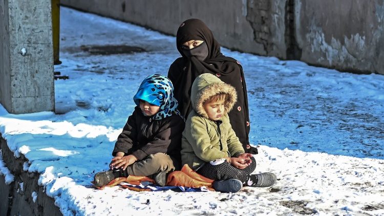 Uma mulher afegã com duas crianças em Kabul