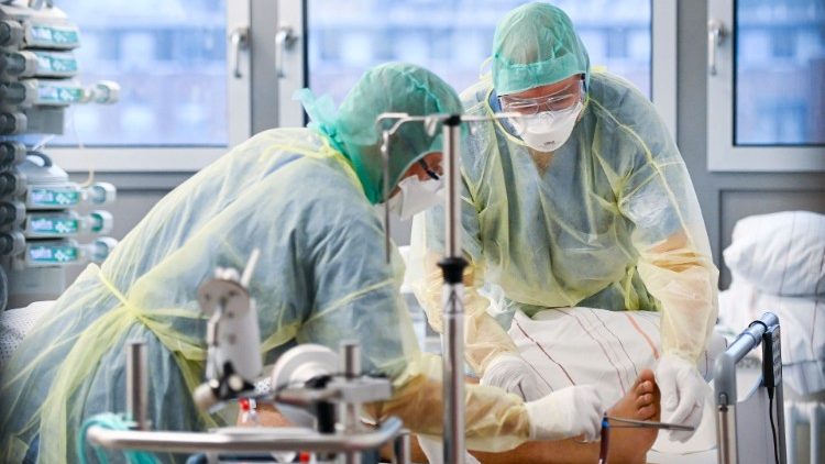 Mitarbeiter im Krankenhaus kümmern sich auf der Intensivstation um einen Corona-Patienten
