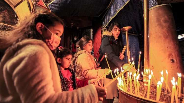 Junge Christinnen und Christen entzünden Kerzen vor der Grotte der Geburtskirche, eine Woche vor Weihnachten in der biblischen Stadt Bethlehem.