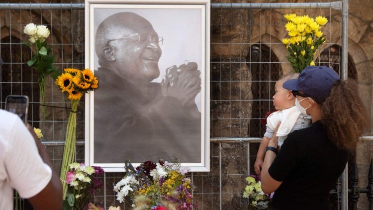 La gente lleva flores a la catedral de St. Georges, donde se ha instalado un mural en memoria de Desmond Tutu