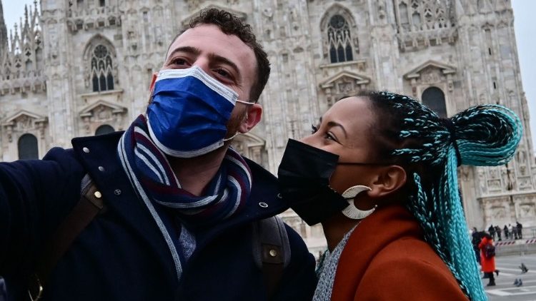 Touristen mit Mund-Nasenschutz vor dem Mailänder Dom - für Gottesdienste empfiehlt die katholische Kirche in Italien inzwischen FFP2-Masken