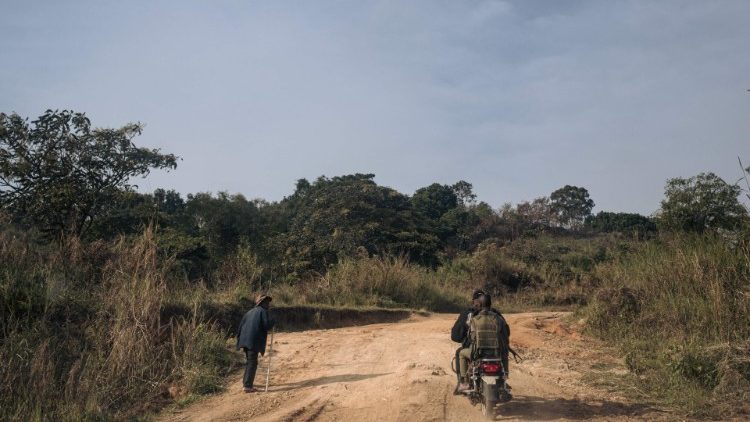 Sicherheitskräfte fahren in der Demokratischen Republik Kongo an einem älteren Mann vorbei