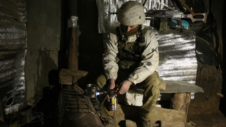 Ein ukrainischer Soldat wärmt sich an der Front zur von Rebellen gehaltenen Donetsk-Region mit einem Tee