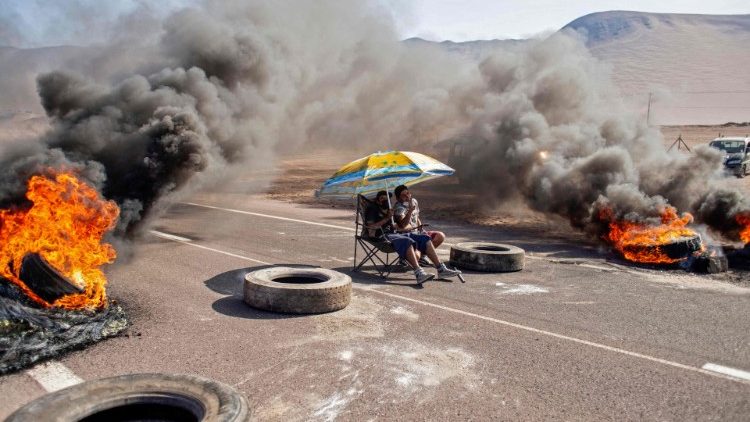 Manifestante se protege del sol mientras bloquea una ruta de acceso a Iquique, durante el paro regional.