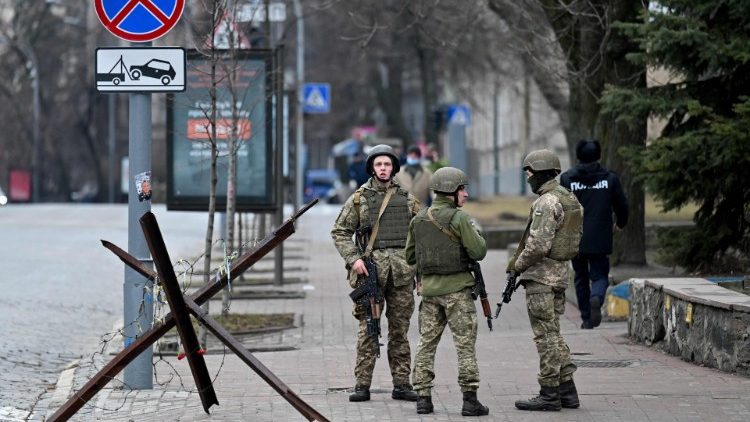 Militares ucranianos bloqueiam estrada no chamado bairro do governo em Kiev em 24 de fevereiro de 2022 (AFP)