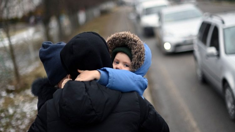 Un papà con un bambino in fuga dall'Ucraina