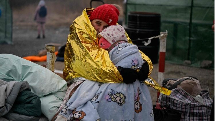 Uma refugiada ucraniana abraça seu filho