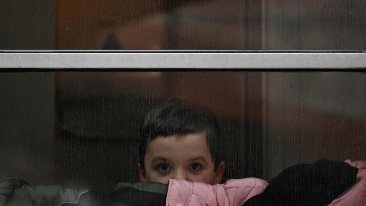 Украінскі хлопец-бежанец глядзіць у акно цягніка на Варшаву