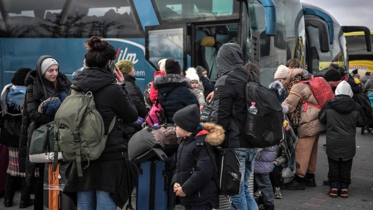 People wait to board buses near the Polish city of Przemysl