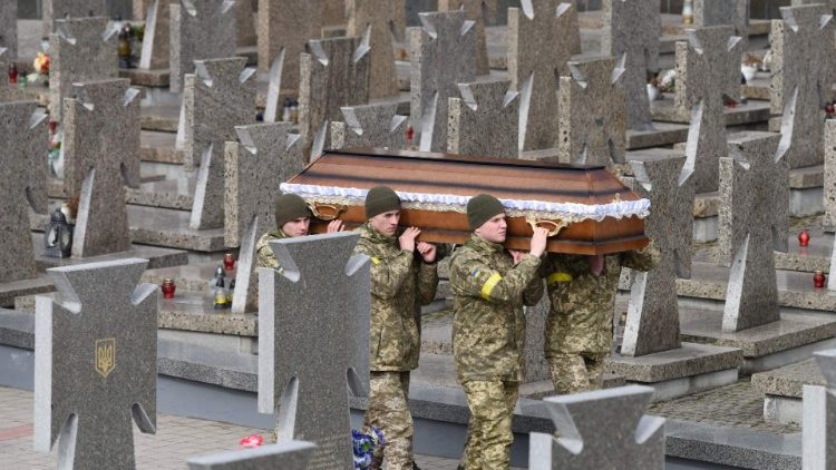 Militares carregam um caixão durante os funerais de Dmytro Kotenko, Vasyl Vyshyvany e Kyrylo Moroz, militares ucranianos mortos durante a invasão russa da Ucrânia, no cemitério Lychakiv, na cidade ucraniana ocidental de Lviv, em 9 de março de 2022. (Foto de Yuriy Dyachyshyn / AFP)