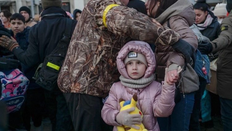 Criança em meio a uma multidão na estação ferroviária central da principal cidade portuária de Odessa, que permanece sob controle ucraniano e até agora foi poupada de combates. (Foto por BULENT KILIC/AFP)] 